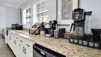 Contemporary kitchen with sleek granite countertops and modern coffee station, perfect for hospitality and efficiency.