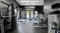 Modern fitness center with state-of-the-art exercise equipment, including treadmills and weight machines in a sleek, well-lit gym space.