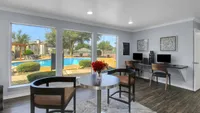 Bright and inviting workspace with modern decor and a stunning pool view, perfect for relaxation and productivity.