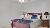 Elegant bedroom with a luxurious wooden bed, plush pillows, and stylish lamps for a cozy ambiance.