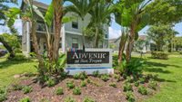 Inviting entrance of Advenir at San Tropez with lush green landscaping and bright blooming flowers, creating a welcoming ambiance.