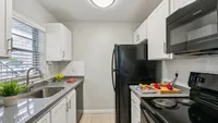 Modern kitchen with sleek white cabinetry, granite countertops, and stainless steel appliances, perfect for gourmet cooking.