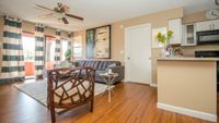 Bright and modern living area with elegant hardwood floors, stylish furniture, and an open-concept kitchen, perfect for entertaining.