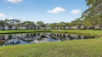 Serene apartment complex surrounded by lush greenery and a picturesque pond, perfect for nature lovers.