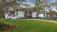 Charming apartment complex surrounded by lush greenery and modern parking facilities, offering a serene living environment.