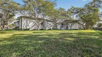 Beautiful apartment complex surrounded by lush greenery and mature trees, offering a tranquil and inviting atmosphere.