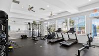 Bright, modern fitness center with treadmills, weightlifting equipment, and large windows providing natural light.