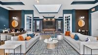 Modern, spacious lounge area with elegant blue and white decor, plush seating, and abundant natural light.