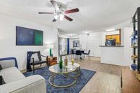 Modern open-concept living and dining area with stylish decor, featuring a cozy living room with elegant furniture, vibrant artwork, and a chic dining space with contemporary accents.