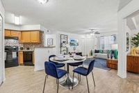 Inviting living space with a modern kitchen and cozy dining area. Featuring a stylish living room with elegant decor, plush seating, and warm wooden accents.