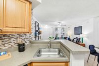 Inviting open-plan living space with a modern kitchen, stylish backsplash, and cozy seating area, perfect for entertaining.