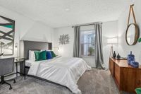 Elegant bedroom featuring a plush bed with crisp white linens, modern decor, and a serene ambiance highlighted by natural light through large windows.