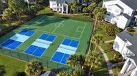 Vibrant residential complex featuring multipurpose sports courts surrounded by lush greenery and modern apartments.