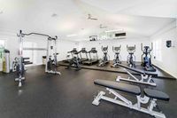 Modern fitness center featuring state-of-the-art gym equipment, treadmills, and aerobic machines in a bright, spacious room.
