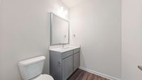 Modern bathroom with sleek gray vanity, large mirror, and elegant lighting. Bright and inviting atmosphere.