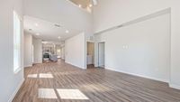 Bright and airy open-concept living space with high ceilings, contemporary kitchen, and stylish wood flooring.