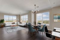 Bright, open-concept living and dining area with large windows, elegant furnishings, and stunning views.