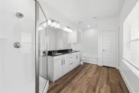 Luxurious modern bathroom with elegant double vanity, sleek glass shower, and inviting bathtub.