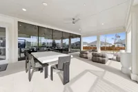 Spacious covered patio with modern dining set and cozy seating area, ideal for outdoor relaxation and entertaining.
