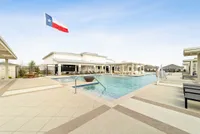 Inviting poolside view with modern amenities and a grand Texas flag, perfect for leisure and relaxation.