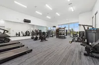 Spacious and modern fitness center with state-of-the-art exercise equipment, offering a bright and inviting workout environment.