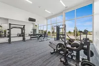Modern gym with state-of-the-art fitness equipment, floor-to-ceiling windows, and serene outdoor views.