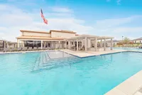 Inviting outdoor pool area with modern loungers and a shaded seating area, perfect for relaxation and enjoyment.
