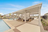 Inviting outdoor lounge area next to a sparkling pool, featuring comfortable seating under a stylish pergola.