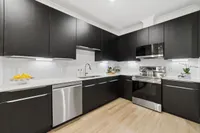 Modern kitchen with dark cabinets and stainless steel appliances in Denton TX rental home near Rayzor Ranch