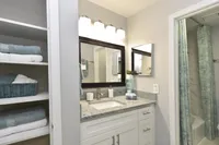 Bright bathroom with granite counters and linen closet