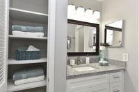 Bright bathroom with granite counters and linen closet