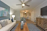 Spacious living room with hardwood-style flooring & overhead lighting