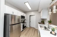 Kitchen with quartz counters, modern cabinetry, & stainless appliances Apartments in Piedmont