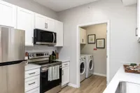 Kitchen & laundry room with hardwood-style flooring Apartments in Piedmont