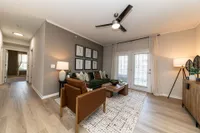 Spacious living room with hardwood-style flooring & overhead lighting Apartments in Piedmont