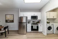 Kitchen and laundry room with hardwood-style flooring & modern cabinetry Apartments in Piedmont