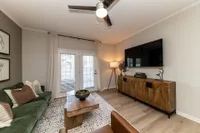 Spacious living room with hardwood-style flooring and overhead lighting Apartments in Piedmont