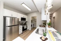 Kitchen with quartz counters, modern cabinetry, & stainless appliances Apartments in Piedmont