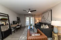 Spacious living room with hardwood-style flooring and overhead lighting Apartments in Piedmont