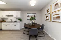 Dining area with hardwood-style flooring and overhead lighting Apartments in Piedmont