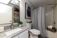 Bright bathroom with granite counters, high-rise faucet, and bathtub Apartments in Piedmont