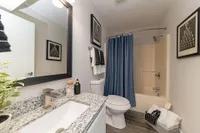 Bright bathroom with granite counters and high rise faucet