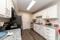 Kitchen with granite counters, modern cabinetry, & hardwood-style flooring