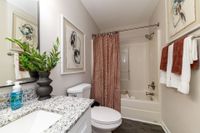 Bright bathroom with granite counters and bathtub