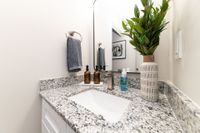 Bright bathroom with granite counters and high rise faucet