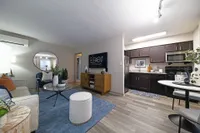 Experience the elegance and comfort of this stylish modern apartment, blending cozy living space with a sleek kitchen.