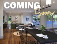 Coming Soon to Slates at Powdersville Bright and modern living area with stylish decor, overlooking a refreshing pool, perfect for relaxation and entertaining.