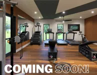 Coming Soon to Slates at Powdersville Upcoming modern fitness center with treadmills, a stair climber, and exercise bike, featuring sleek wooden flooring and ample natural light.