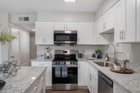 Kitchen with granite counters, stainless appliances, and modern cabinetry