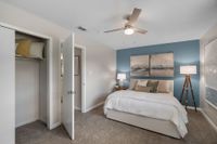 Bedroom with carpet, generous closet space, & ceiling fan